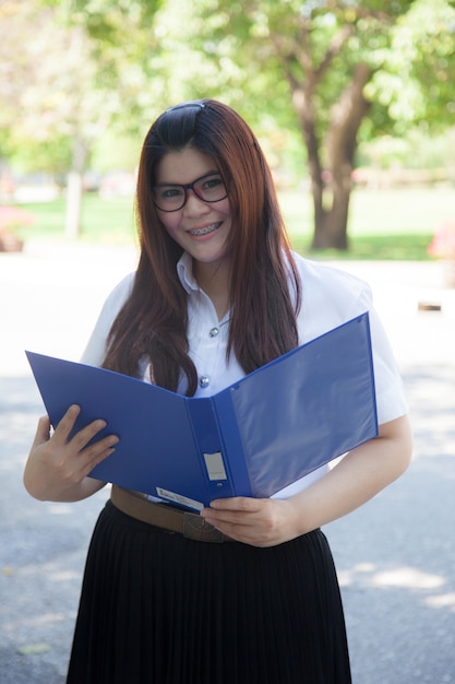 Student, der blaue Dokumente anhält.