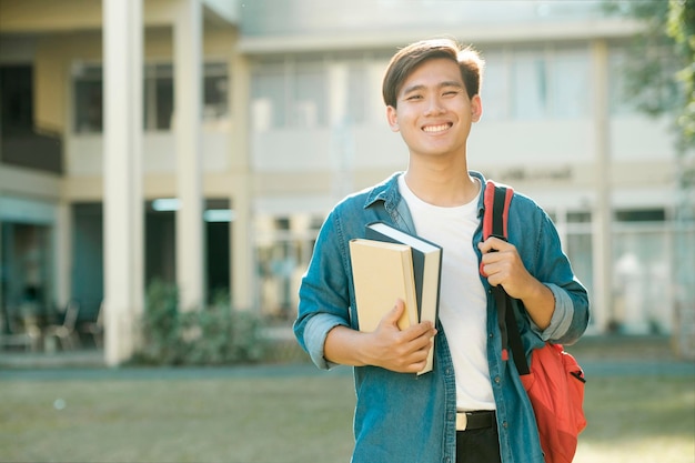 Student, der draußen steht und Bücher hält