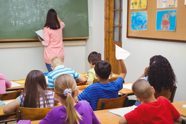 Student, der ein Papierflugzeug wirft