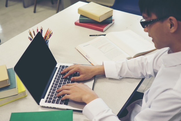 Student, der Forschung auf Laptop macht und Internet durchstöbern. Bildungskonzept.