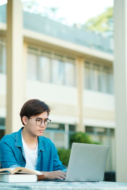 Student, der im Freien unter Verwendung des Laptops studiert