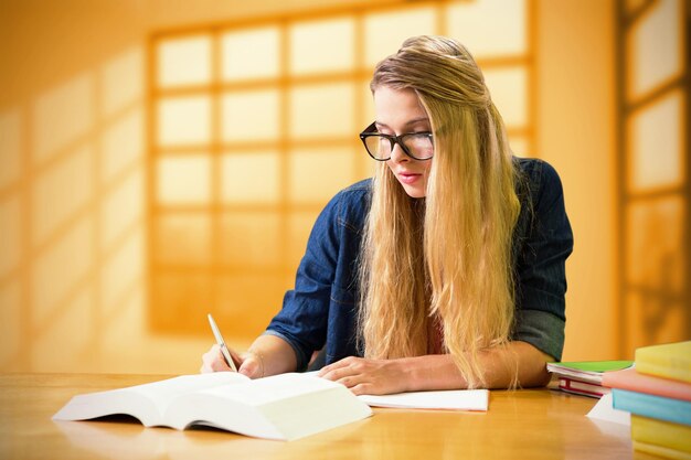 Student, der in der Bibliothek gegen Raum mit großem Fenster studiert, das Stadt zeigt