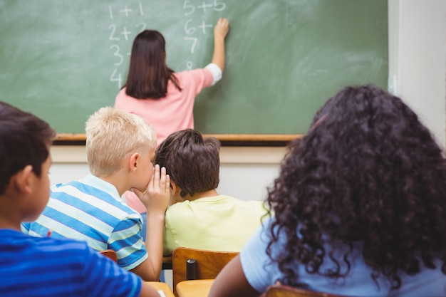 Student, der in ein anderes Studentenohr flüstert