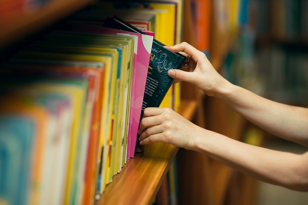 Student, der nach Büchern in einer Bibliothek sucht