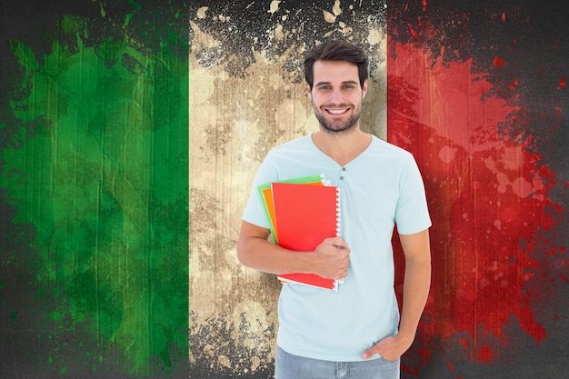 Foto student, der notizblock gegen italien-flagge im schmutzeffekt hält