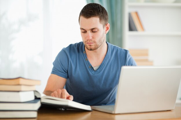 Student, der seinen Laptop für seine Hausarbeit verwendet