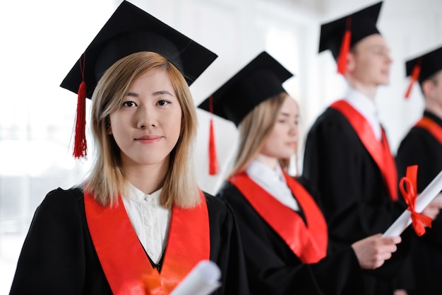 Student im Junggesellengewand mit Diplom drinnen. Abschluss-Tag