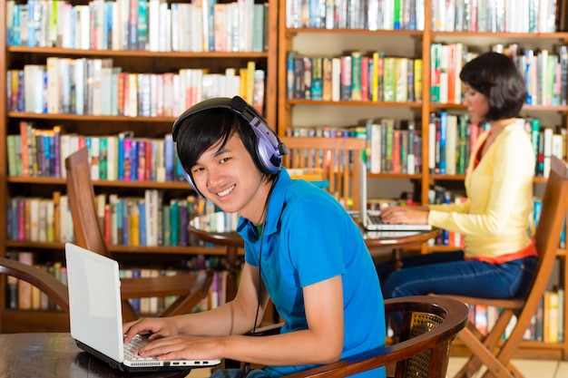 Student in der Bibliothek mit Laptop