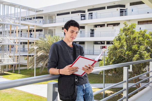 Student liest ein Buch auf dem Campus