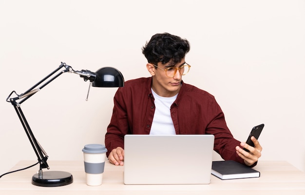 Student Mann an einem Arbeitsplatz mit einem Laptop