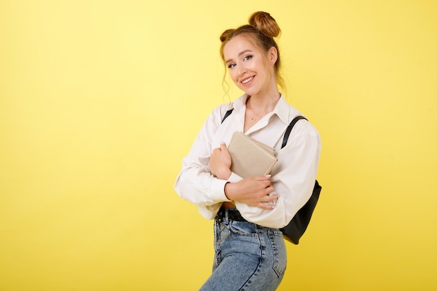 Student mit Büchern und einem Rucksack im Raum