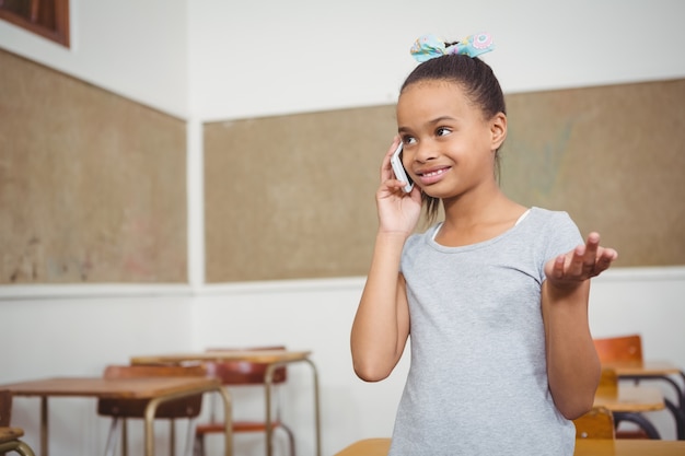 Student mit einem Mobiltelefon in der Klasse