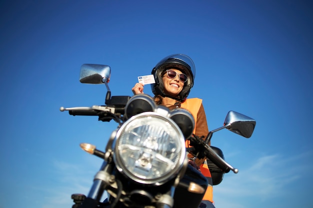 Student mit Helm und Warnweste, der Motorrad auf Klasse fährt.