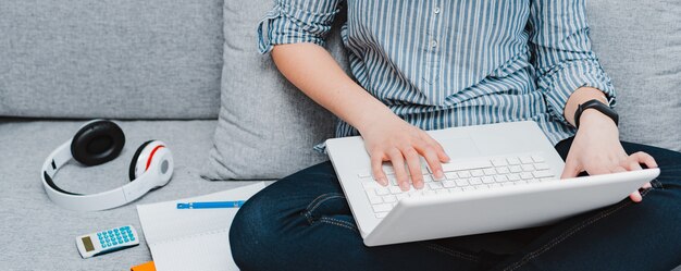 Student mit Laptop am Sofa