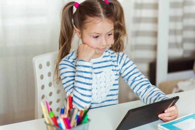 Student mit Tablette, Büchern und Papieren, zu Hause studieren