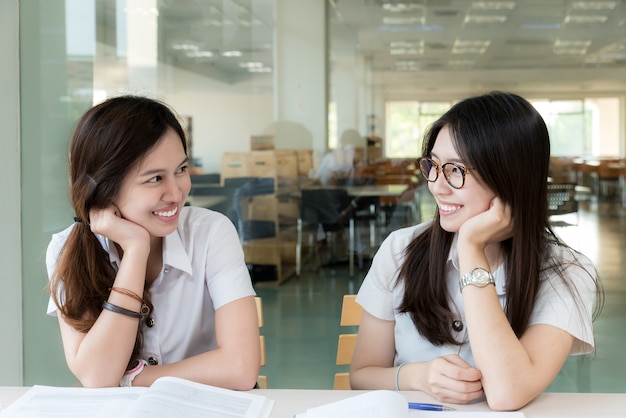 Student mit zwei Asiaten in der einheitlichen Studie im Klassenzimmer.