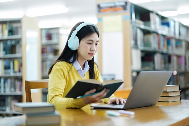 Student sitzt und studiert mit Laptop in der Bibliothek