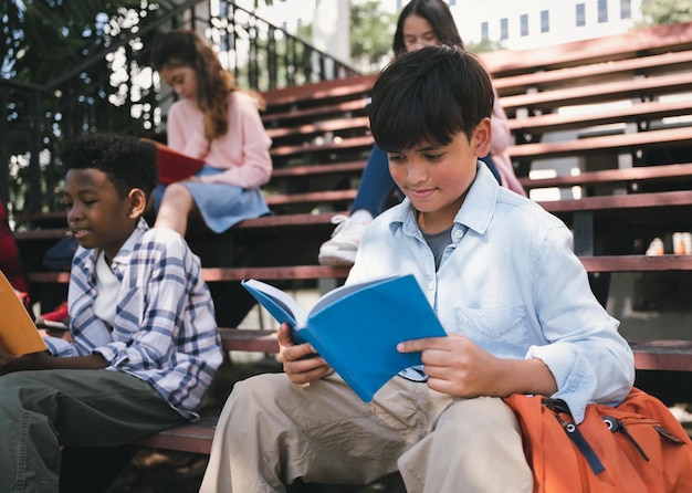 Student smart boy Lesebuch mit Freund im Schulpark