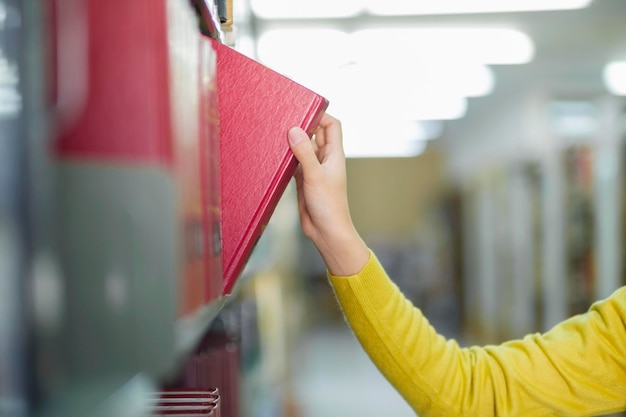 Student wählt und liest Buch in der Bibliothek