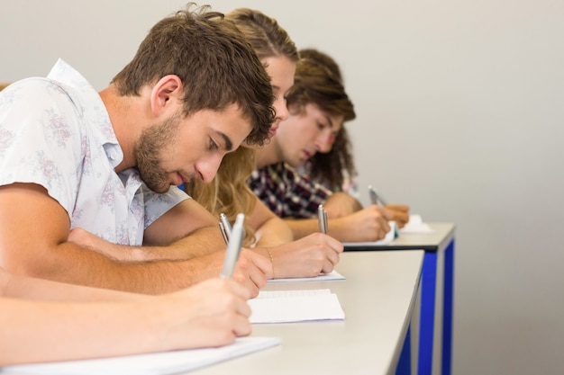 Studenten, die Anmerkungen in Klassenzimmer schreiben