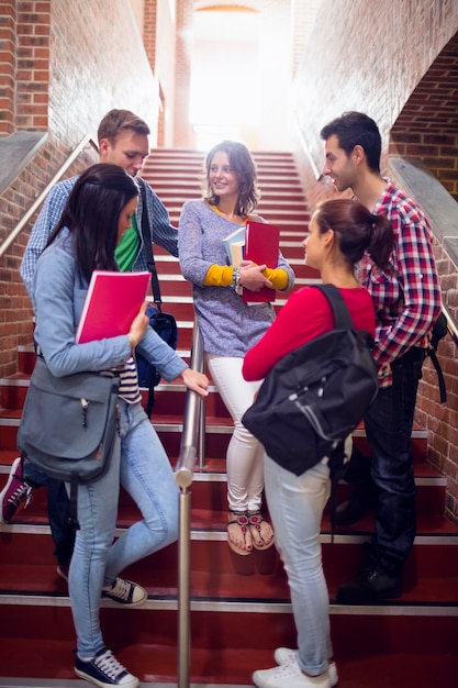 Studenten, die auf Treppe im College sich unterhalten