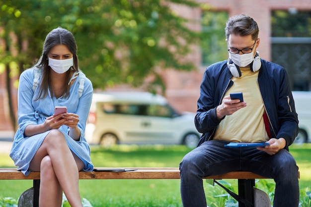 Studenten, die aufgrund der Coronavirus-Pandemie mit Schutzmasken und Abstand auf dem Campus herumhängen