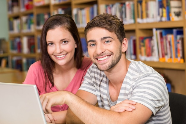 Studenten, die Laptop in der Bibliothek verwenden