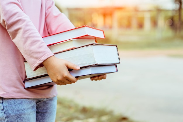 Studenten halten ein Buch auf dem Campus.