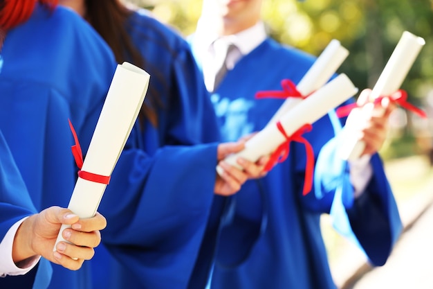 Studenten im Aufbaustudium mit Diplomen in der Nähe