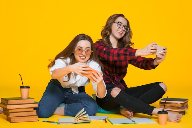 Studenten Mädchen Glückliche junge Frau Studenten mit Notebooks auf gelb Student an der Hochschule