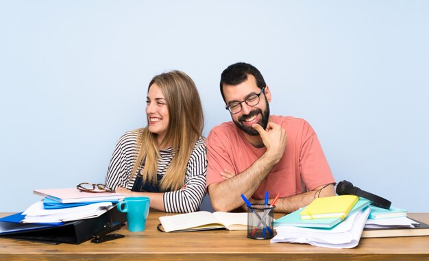 Studenten mit vielen Büchern mit verschränkten Armen und glücklich