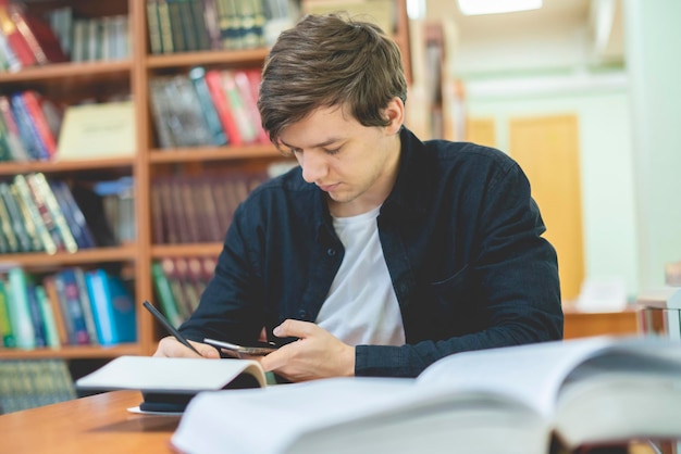 Studenten nutzen das Telefon während des Studiums an der Universität b