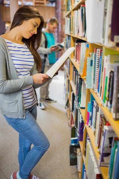 Studenten stehen Bücherregal in der Bibliothek