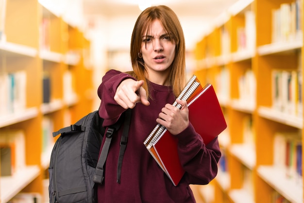 Studentenfrau, die auf unfocused Hintergrund schreit. zurück zur Schule