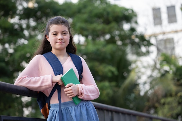 Studentenmädchen, das Buchschulpark hält