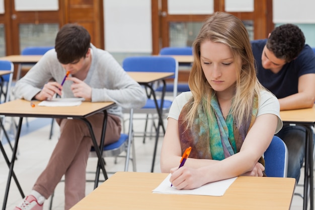 Studentin, die bei Tisch am Klassenzimmer sitzt