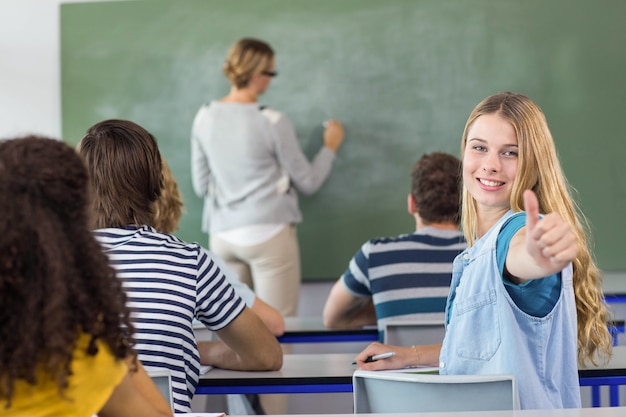 Studentin, die Daumen oben in der Klasse gestikuliert