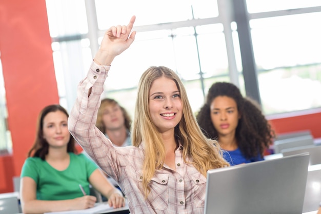 Studentin, die Hand im Klassenzimmer anhebt