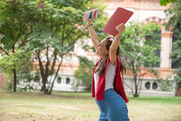 Studentin, die ihre Hand für Glück anhebt