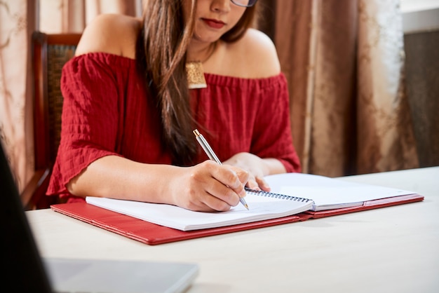 Studentin, die im Lehrbuch schreibt