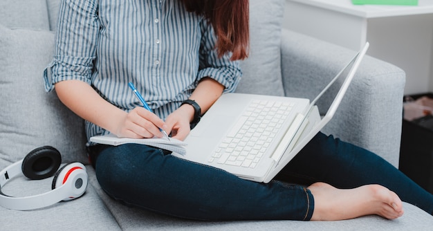 Studentin, die mit ihrem Laptop nach Hause lernt