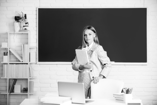 Studentin hält Buch im Klassenzimmer und bereitet sich auf die Prüfung vor