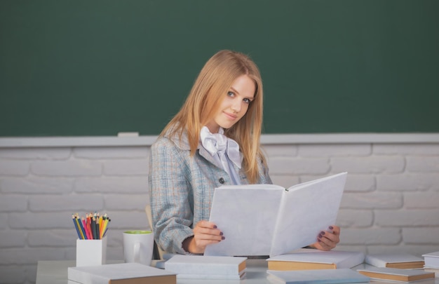 Studentin hält Buch über Unterrichtsvorlesung im Klassenzimmer an der High School oder am College.