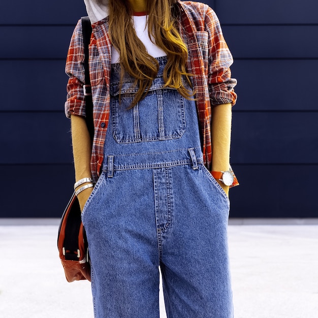 Studentin. In modischen Denim-Overalls. Urbaner Stil