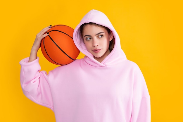 Studentin mit Basketballball auf gelbem Hintergrund