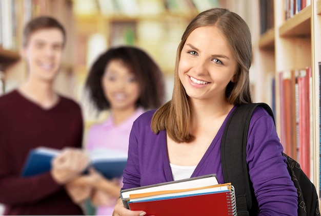 Studentin mit Büchern und Tasche auf dem Campus