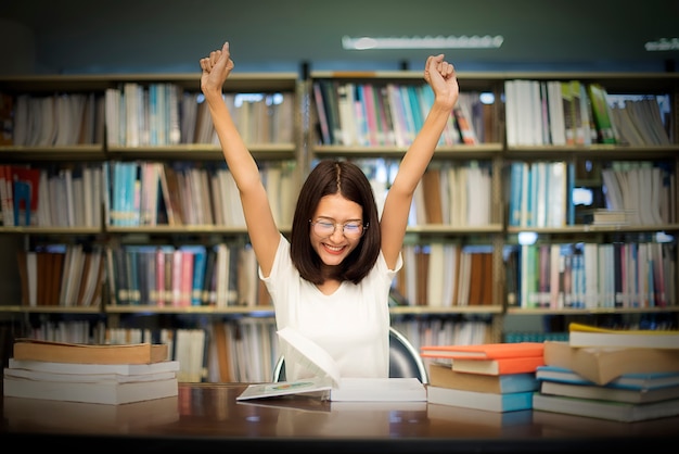 Studentin mit Gläsern Lesebüchern in der Bibliothek