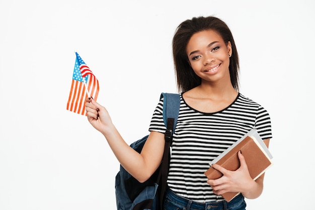 Studentin mit Rucksack, der Bücher und US-Flagge hält