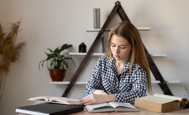 Studentin schreibt Hausaufgaben, während sie zu Hause aus der Ferne online über das Netzwerk lernt Lehrerin einer modernen Schule, die sich auf den Unterricht im Büro vorbereitet Fernunterricht und Geschäftskonzept