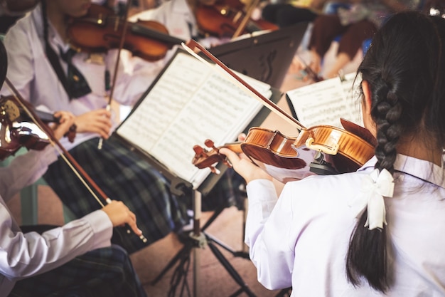 Studentinnen spielen Violine in der Gruppe.